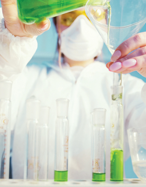 Woman pouring green solution through funnel in lab